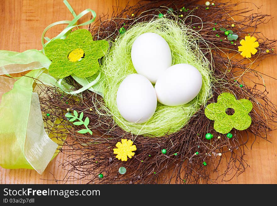 Spring nest with three white eggs in it