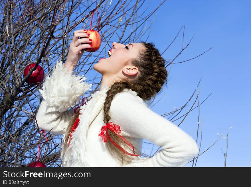 Funny girl eating apple outdoor