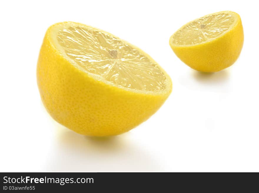 Two lemon halves arranged over white background