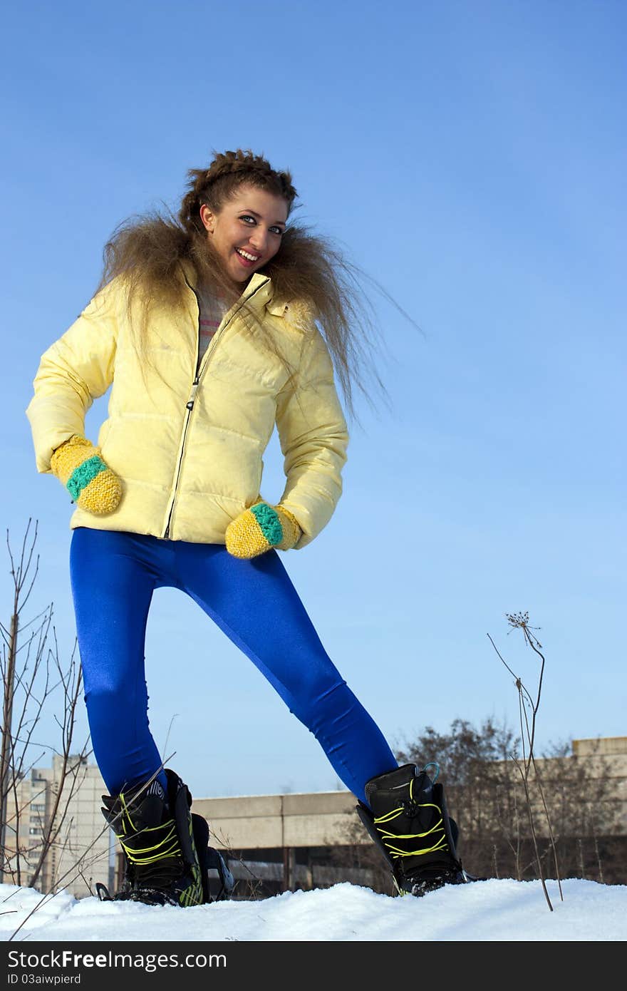 Beautiful girl in a yellow jacket in winter