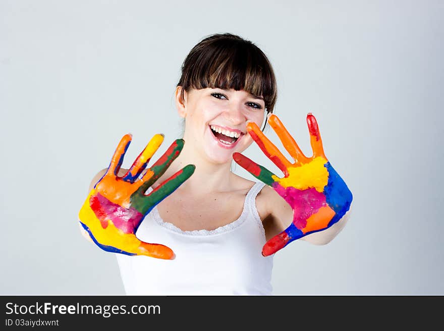 A girl with colored hands on a gray background