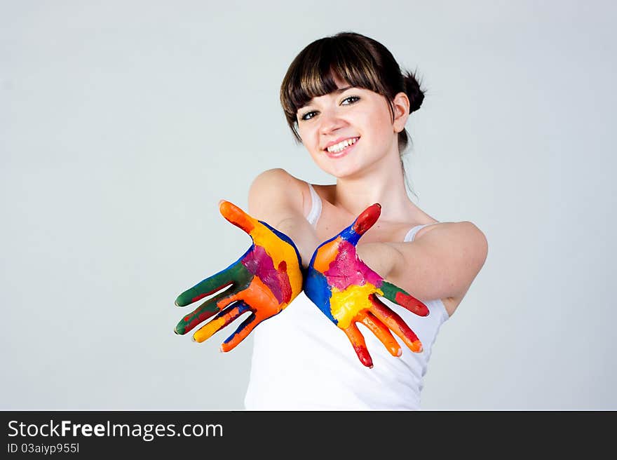 A girl with colored hands on a gray background