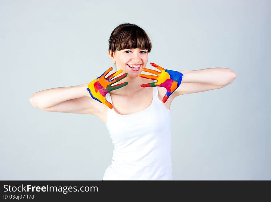 A girl with colored hands on a gray background