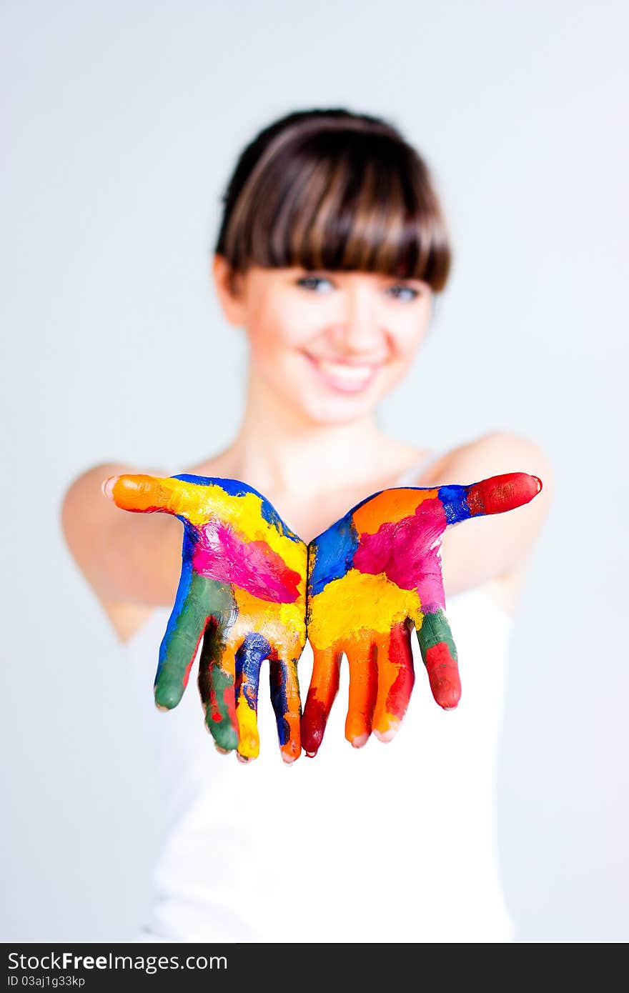 A girl with colored hands on a gray background