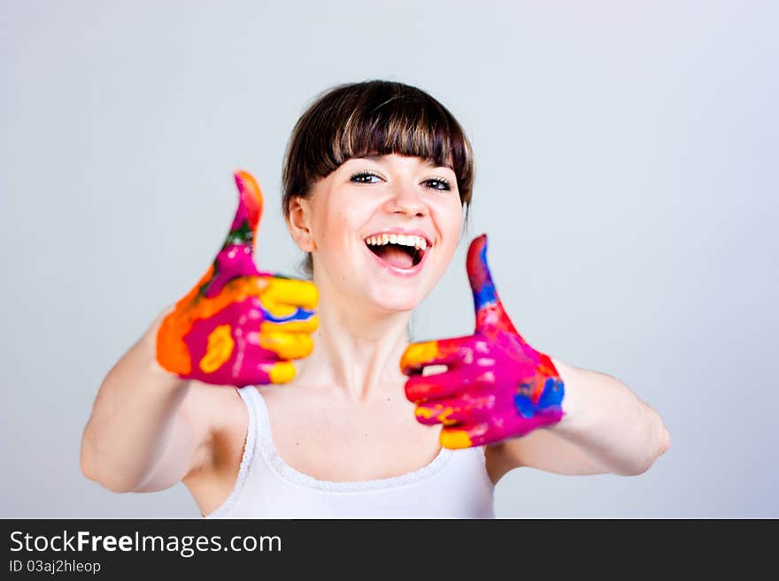 A girl with colored hands on a gray background