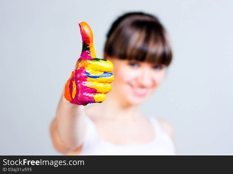 A girl with colored hands on a gray background