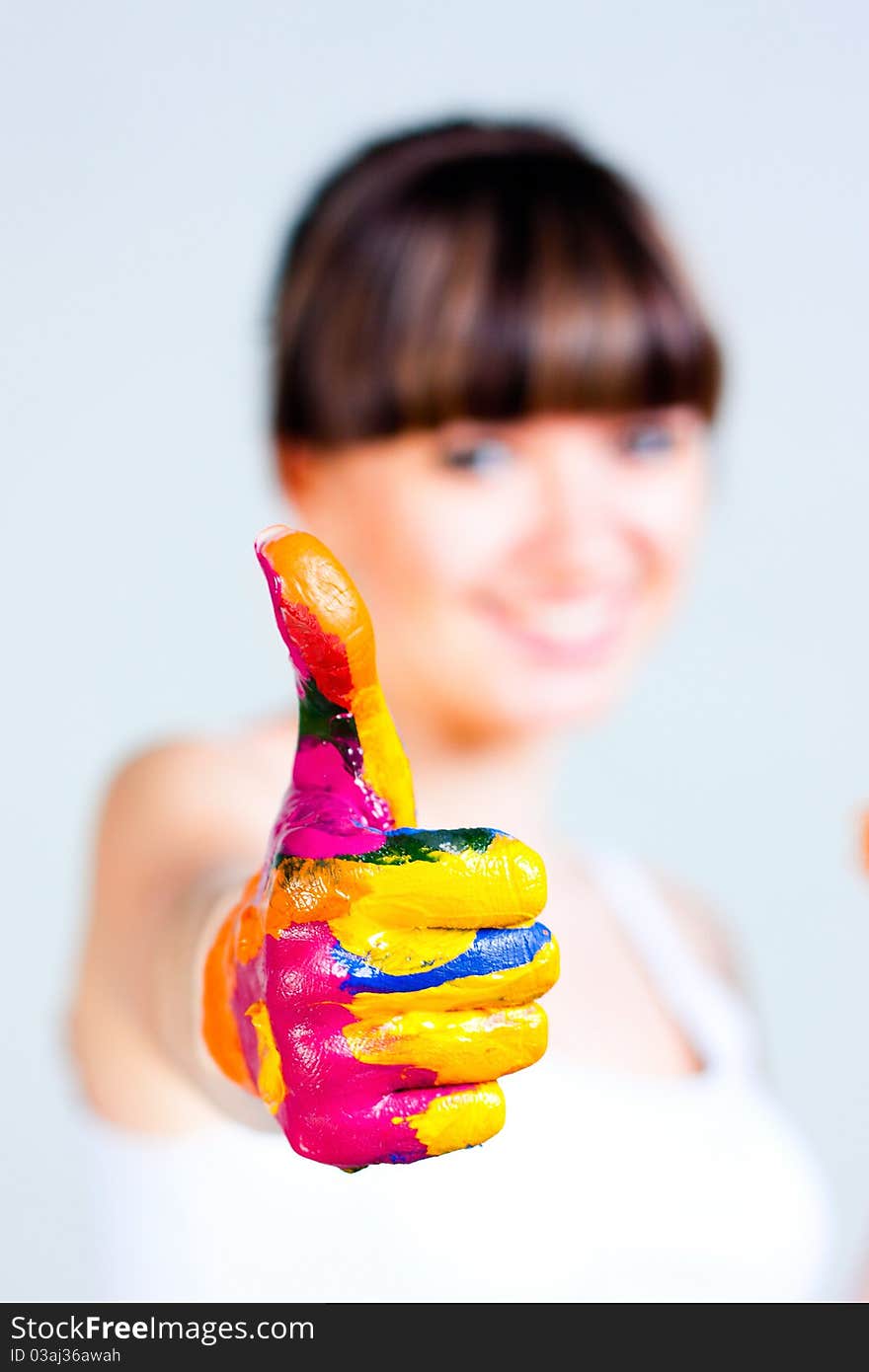 A girl with colored hands on a gray background