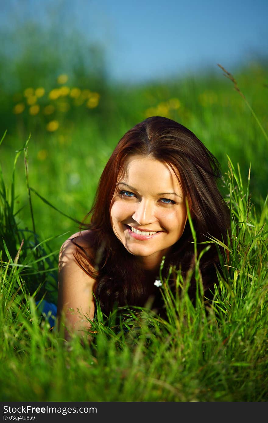 Brunette lays on green grass. Brunette lays on green grass