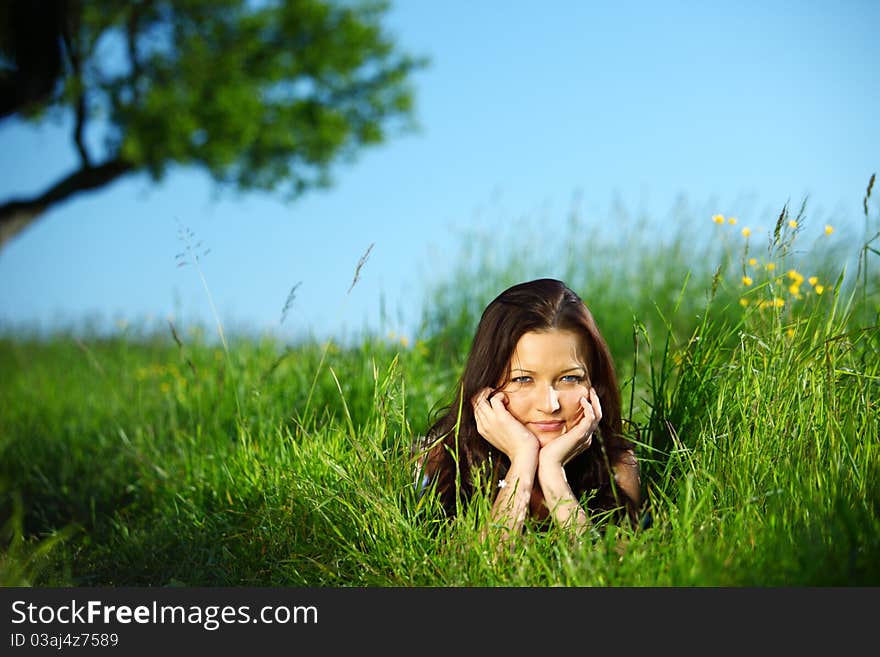 Brunette lays under the tree. Brunette lays under the tree