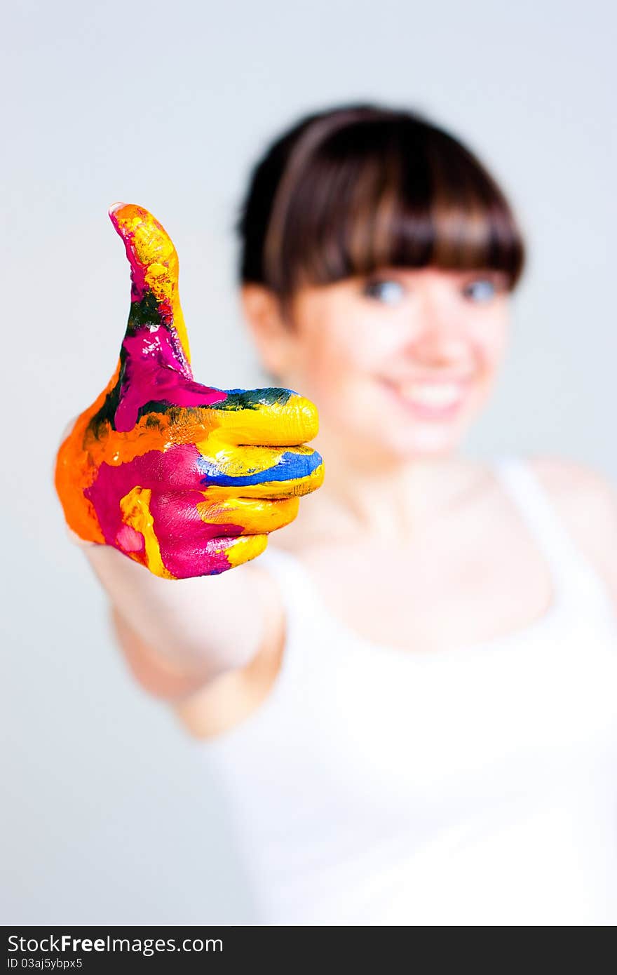 A girl with colored hands on a gray background