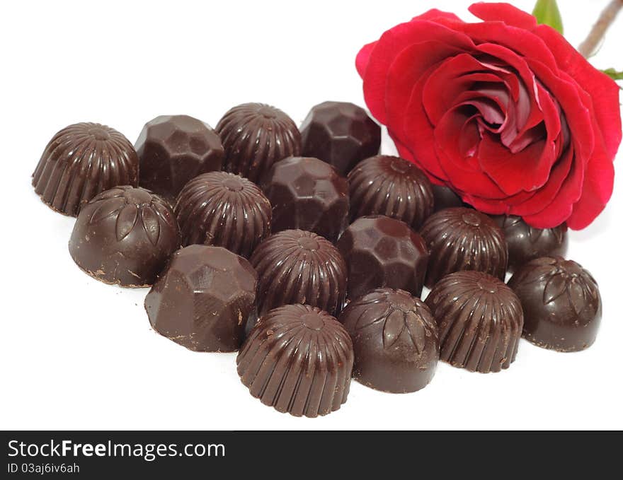 Beautiful red rose and chocolate on white background