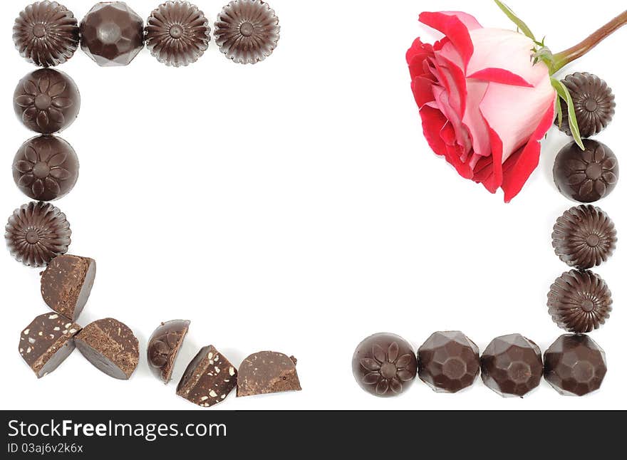 Beautiful red rose and chocolate frame on white background