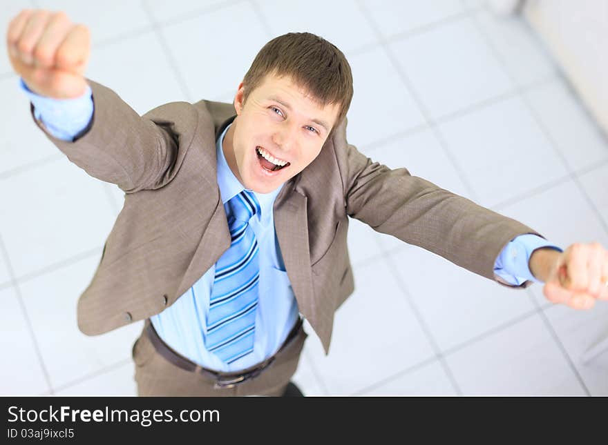 Happy businessman standing outside with arms outstretched