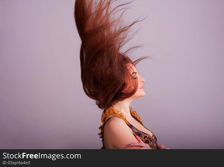 Portrait of a pretty girl with hair fluttering in the wind