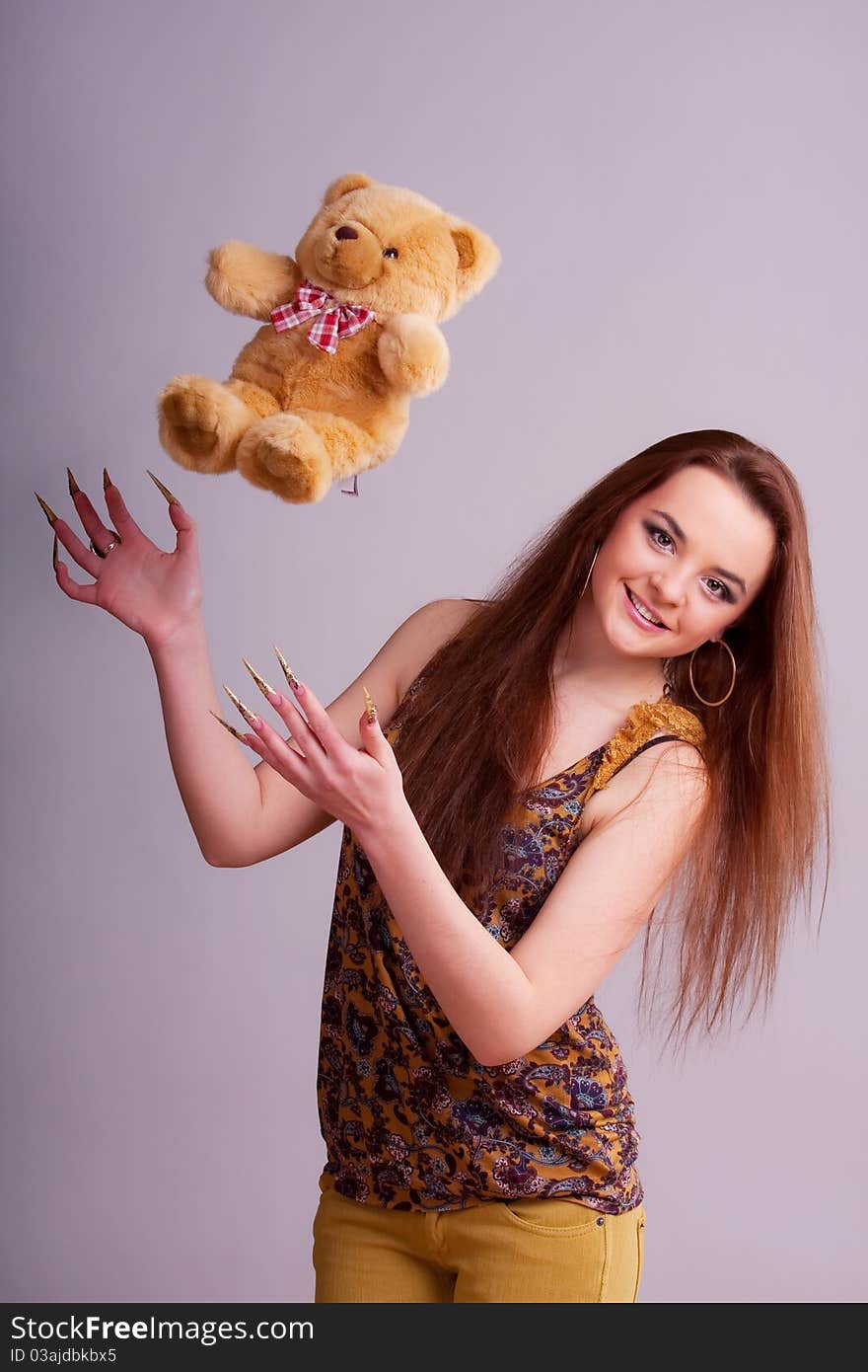 Beautiful young longhair brunette playing with bear. Beautiful young longhair brunette playing with bear