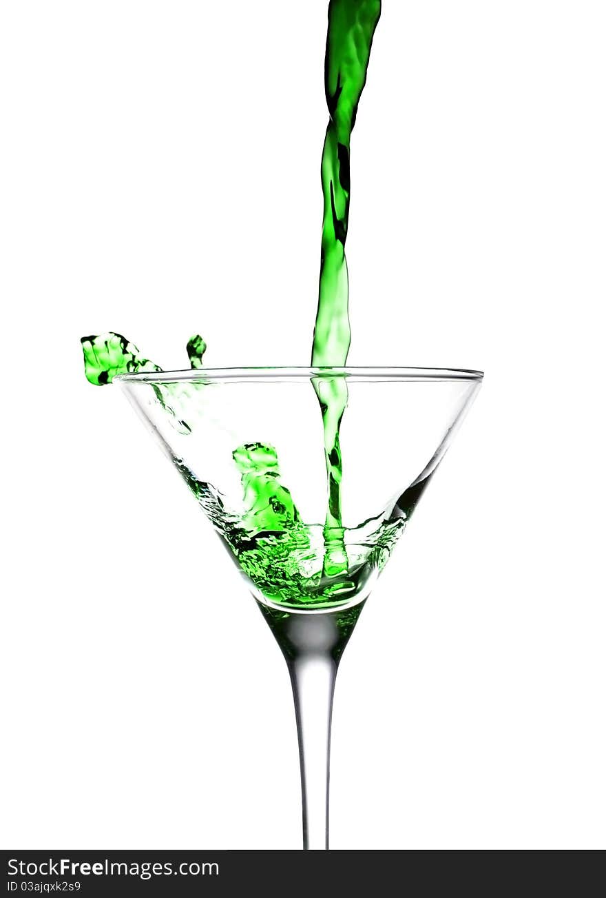 Green drink fall into glass on white background