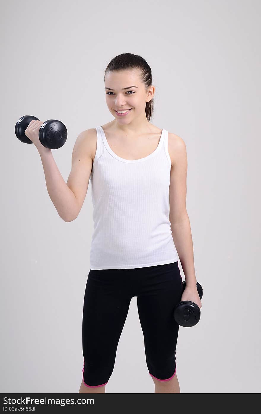 Beautiful young woman working out with dumbbells. Beautiful young woman working out with dumbbells