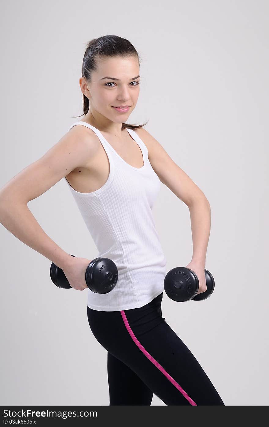 Beautiful young woman working out with dumbbells. Beautiful young woman working out with dumbbells