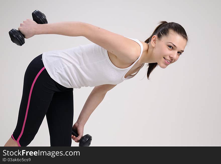 Beautiful attractive girl working out with dumbbells. Beautiful attractive girl working out with dumbbells