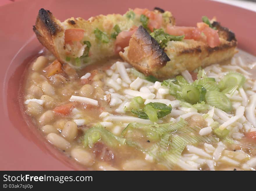 Bowl of fresh made northern beans with garlic bread and onions. Bowl of fresh made northern beans with garlic bread and onions.