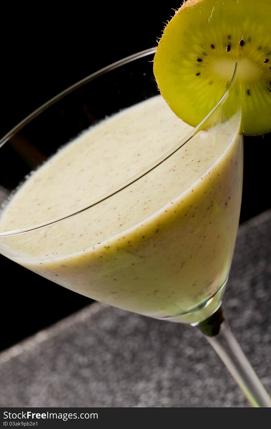 Photo of delicious kiwi milkshake in cocktailglass with kiwi slice on it