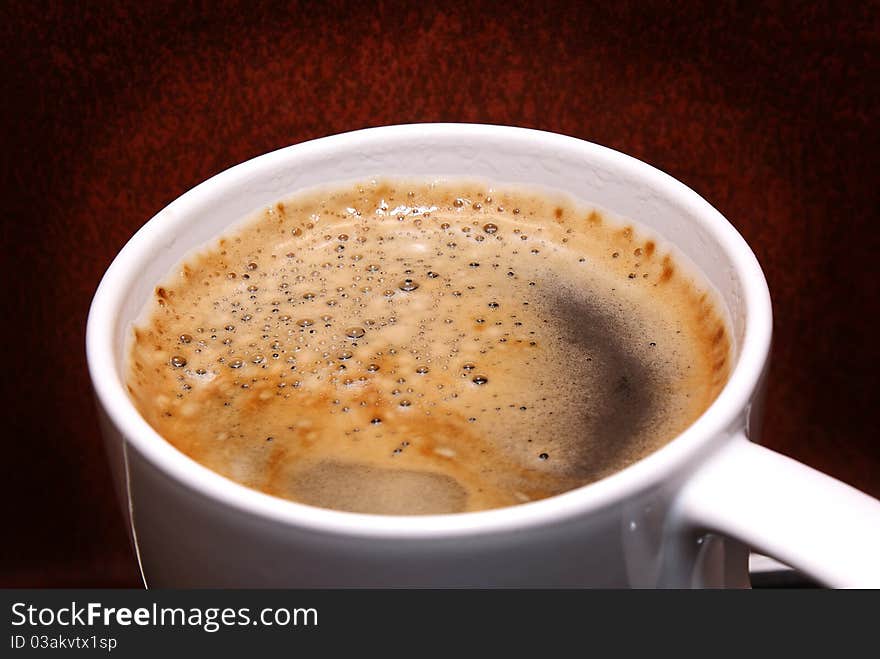 Coffee with cream on a brown background.