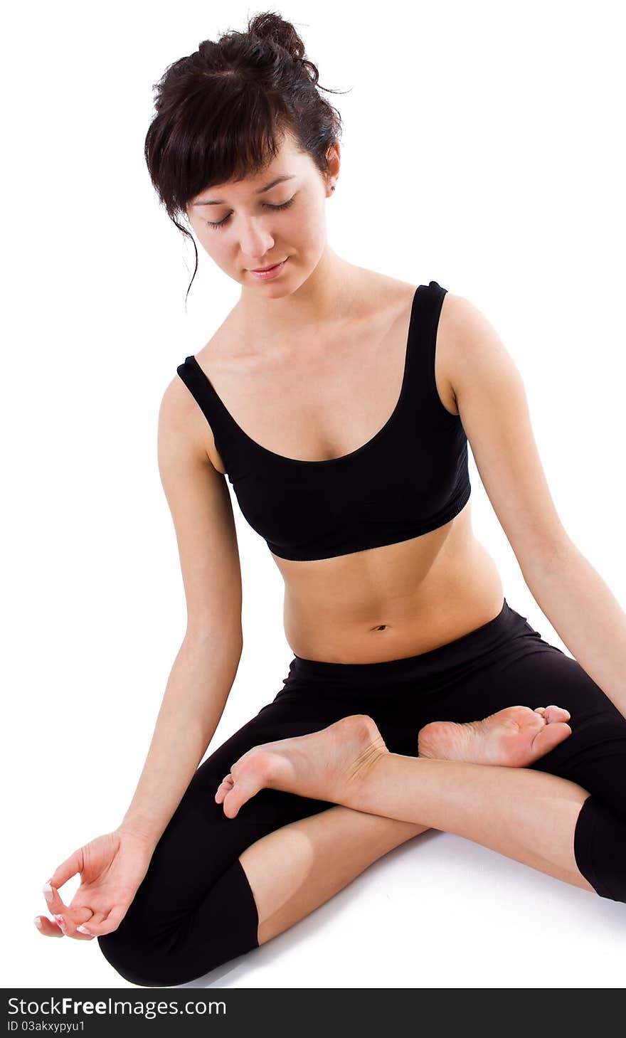 Young girl sitting on the white background dooing yoga. Young girl sitting on the white background dooing yoga