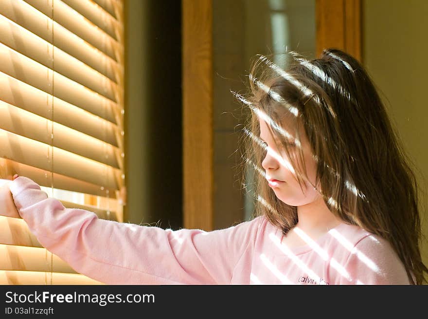 A picture of a young girl stuck inside wishing she were outside. A picture of a young girl stuck inside wishing she were outside