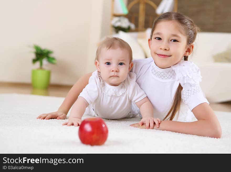 An older sister playing with a toddler sister at home. An older sister playing with a toddler sister at home