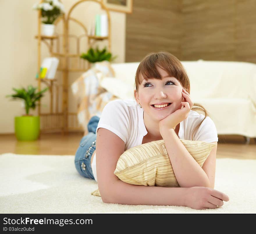 A young girl with at home relaxing on the carpet in her living room. A young girl with at home relaxing on the carpet in her living room