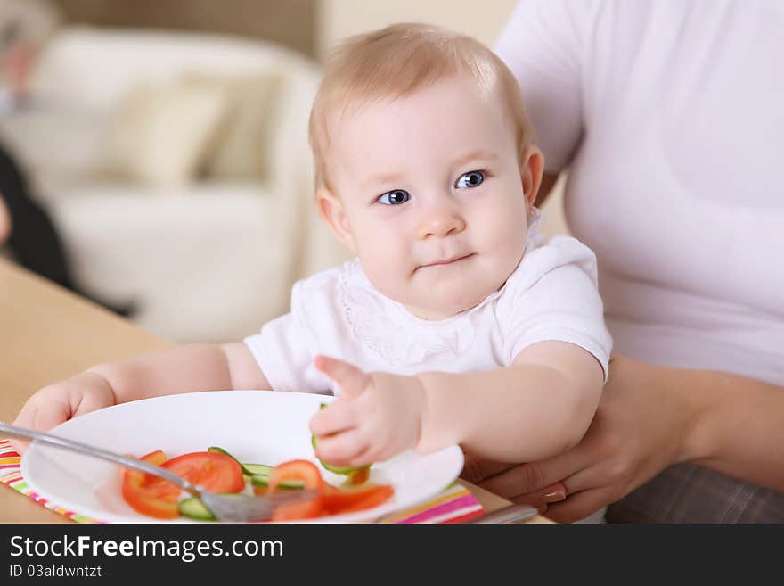 A young mother feeding her infant baby at home. A young mother feeding her infant baby at home