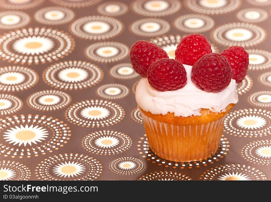 Cup cake with raspberries on nice interesting background