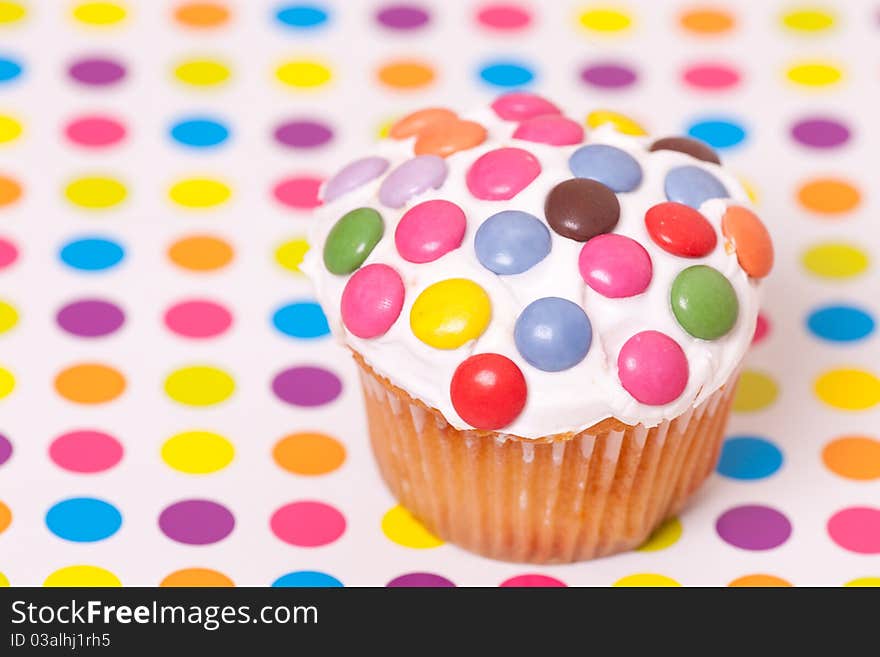 Decorated cup cake on spotty background