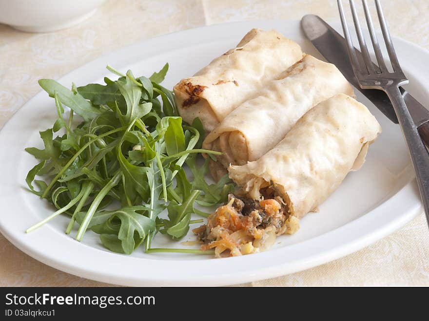 Fresh duck spring rolls with rocket on a plate