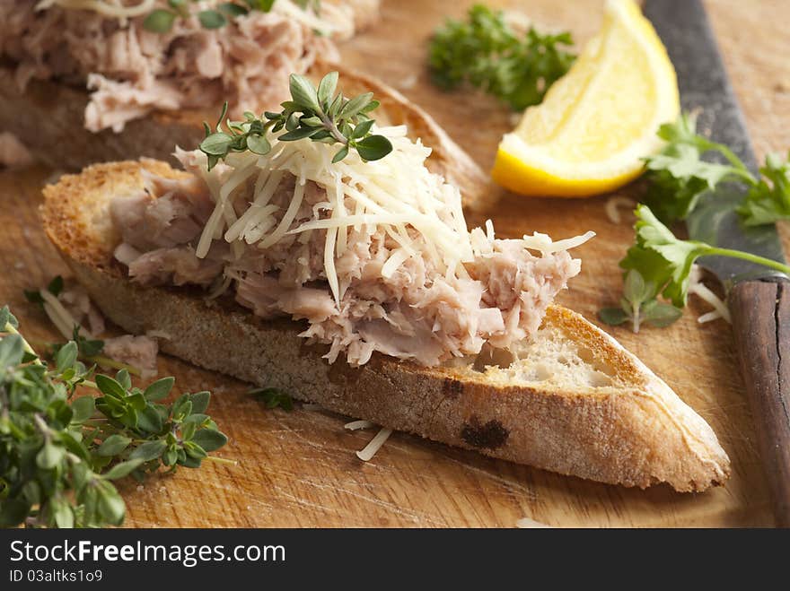 Toasted bread topped with tuna and grated cheese