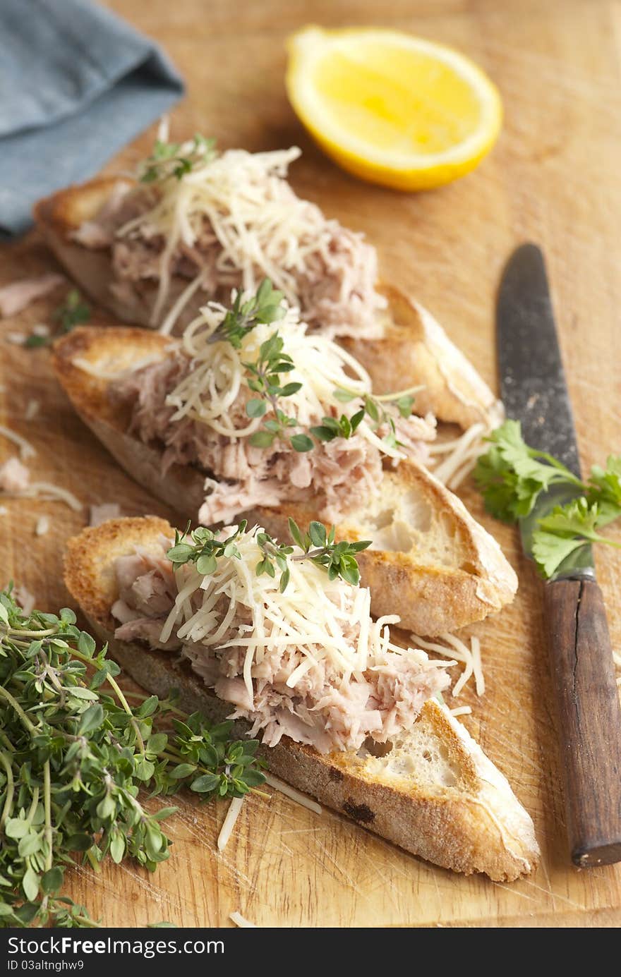 Toasted bread topped with tuna and grated cheese