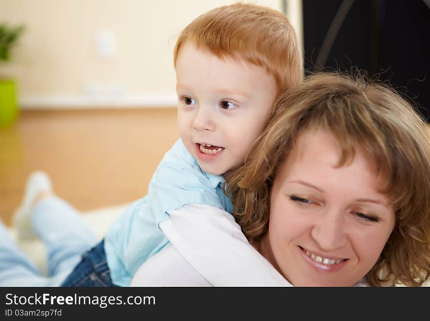 Young mother having fun with her little son at home on the floor. Young mother having fun with her little son at home on the floor