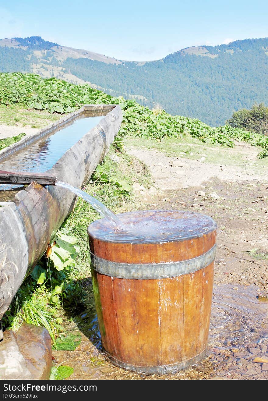 The water from the stream flows in the barrel