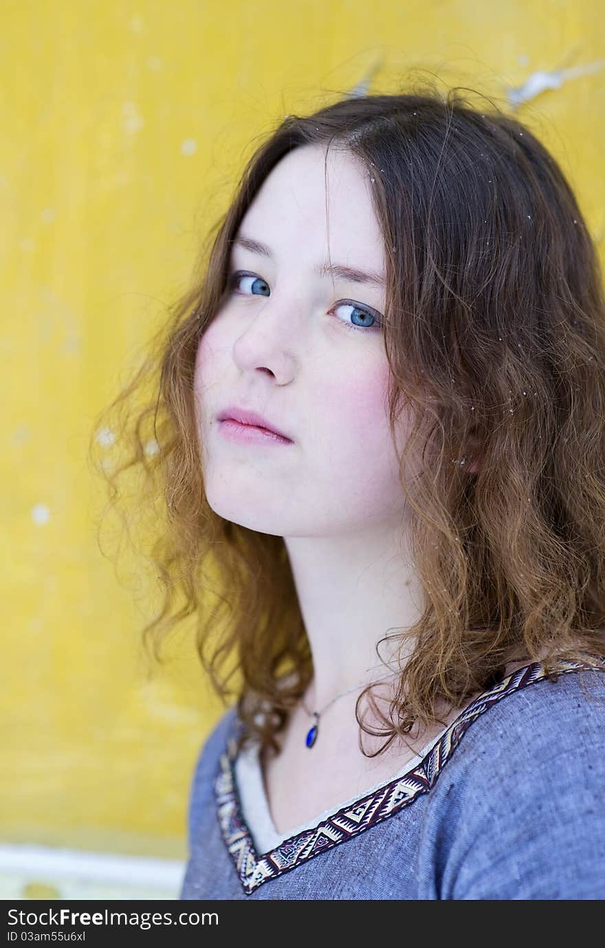 Young girl with wavy hair on the yellow background. Young girl with wavy hair on the yellow background