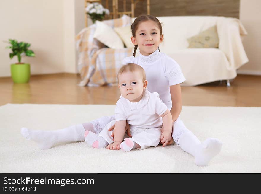 An older sister playing with a toddler sister at home. An older sister playing with a toddler sister at home