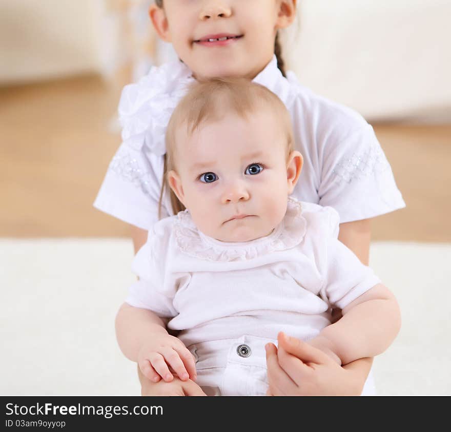 An older sister playing with a toddler sister at home. An older sister playing with a toddler sister at home