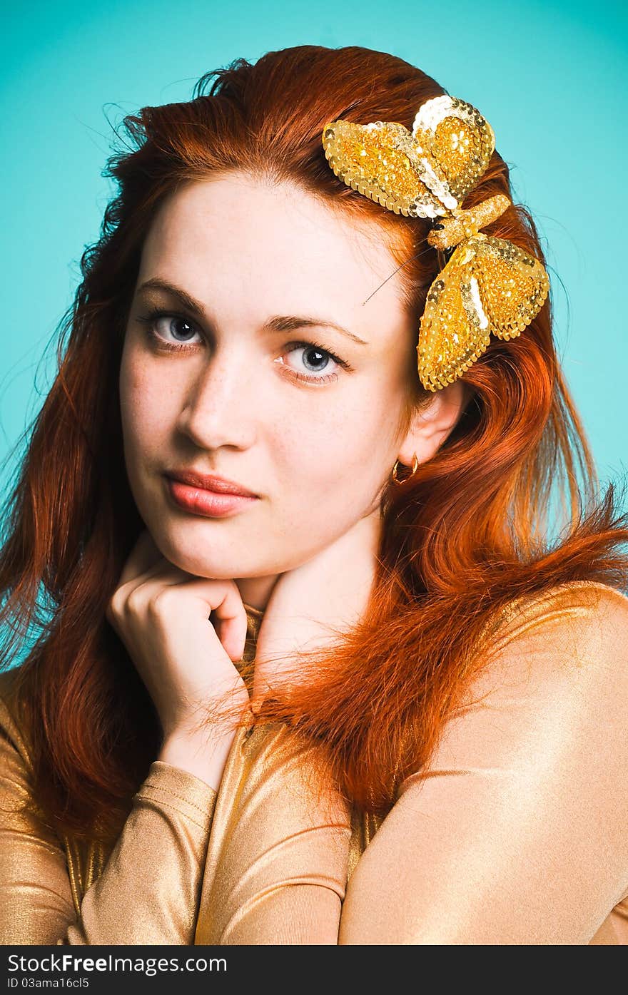 Beautiful girl with a golden butterfly in her hair