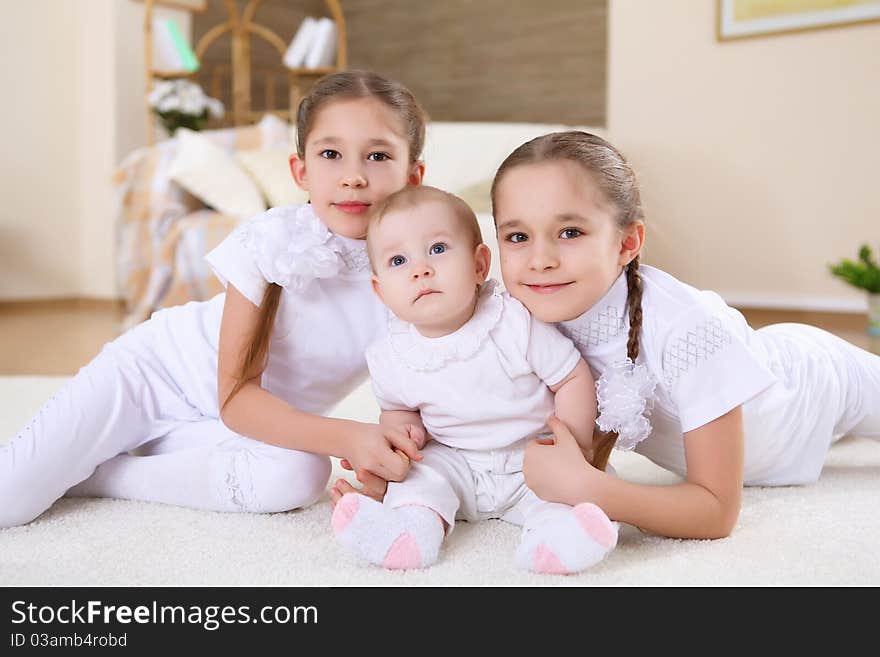 Two twin sisters at home together laying at the floor. Two twin sisters at home together laying at the floor