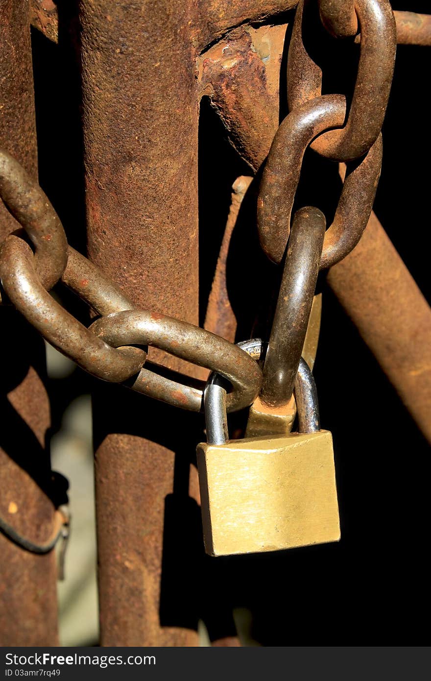 Old rusty gate locked with a chain and padlock. Old rusty gate locked with a chain and padlock