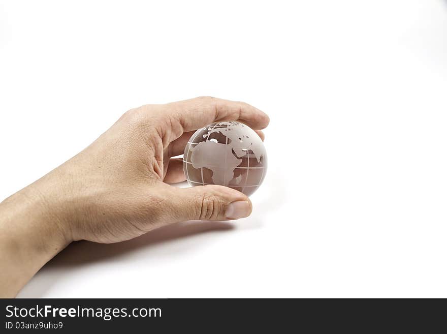 A hand holding a glass miniature of the world. A hand holding a glass miniature of the world