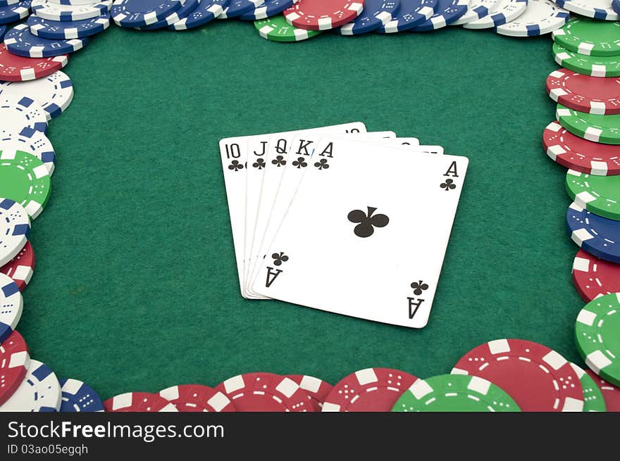 Royal flush and chips on a green table