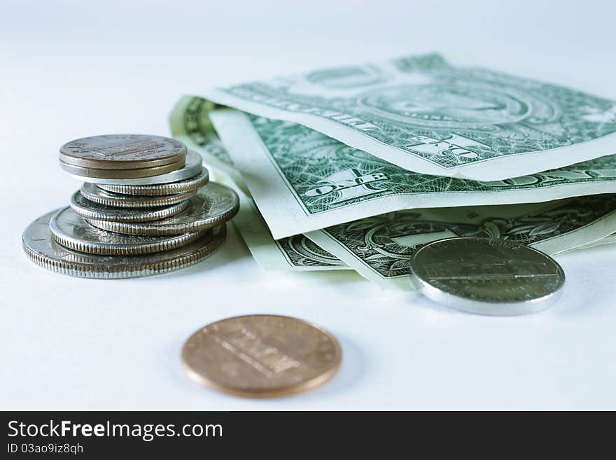 Stacked coins and dollar bills isolated on a white background. Stacked coins and dollar bills isolated on a white background