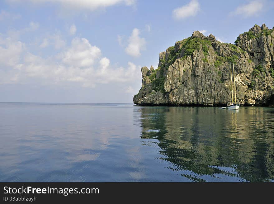 Thai island with yacht in calm water