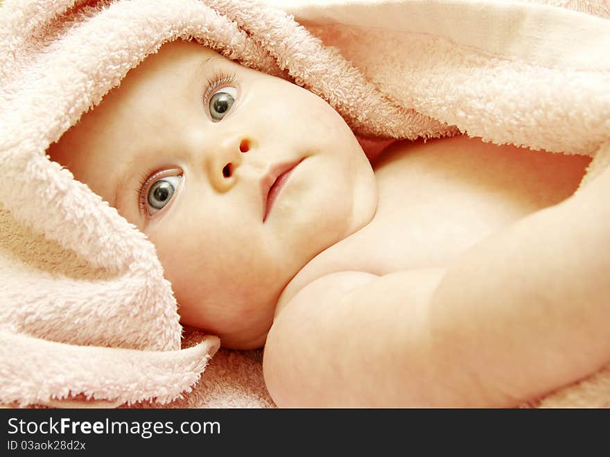 Baby looking out from under blanket