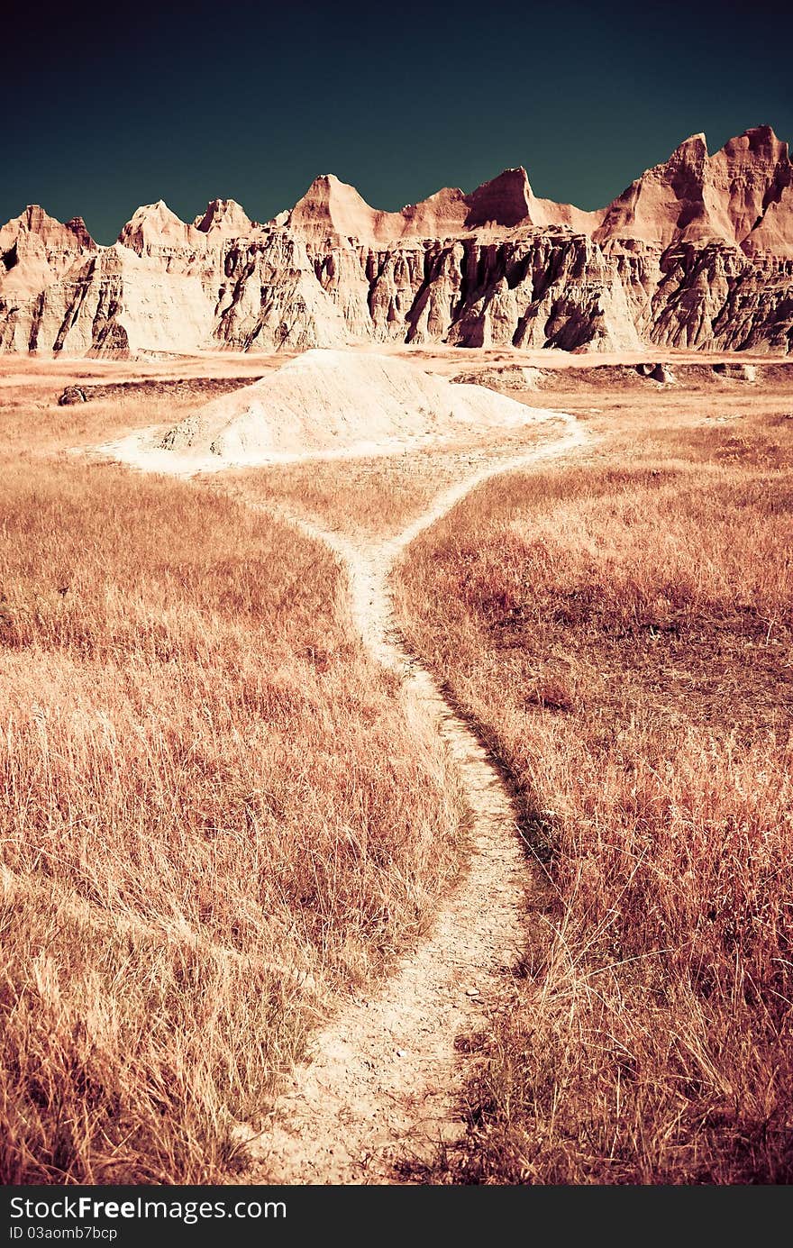 A dry pathway leads to mountains of sand. A dry pathway leads to mountains of sand